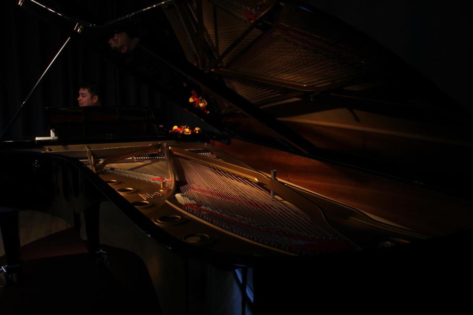Pianisten Patricio Moya Obel i mørket bag det store klaver. 